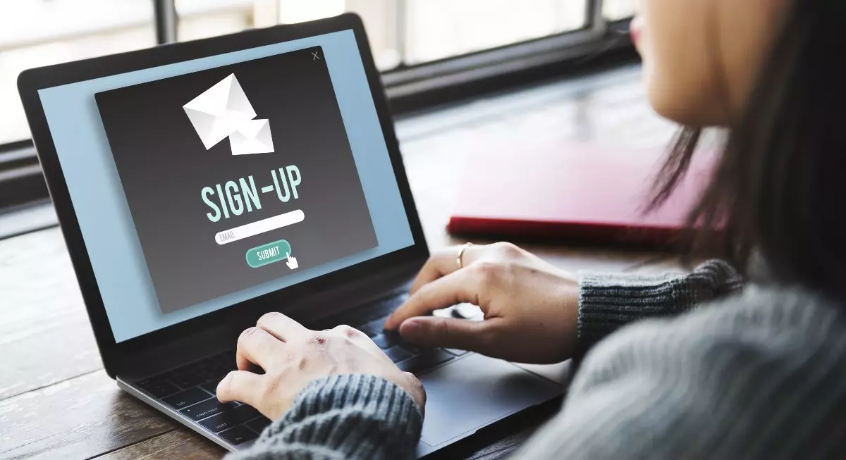Individual completing online sign up form on laptop